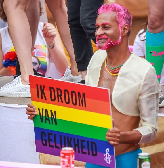 Deelnemer aan Pride met een bord: ik droom van gelijkheid.