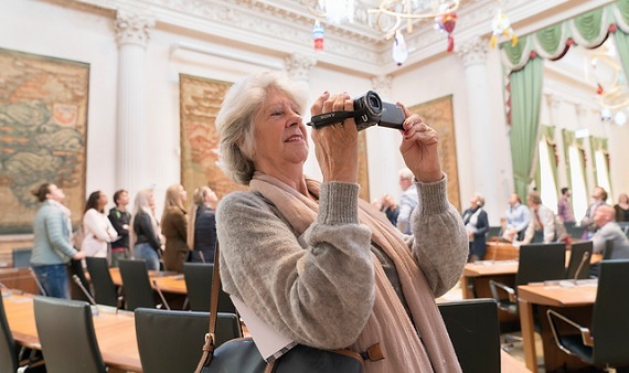 Bezoeker fotografeert tijdens een rondleiding in de Statenzaal van het provinciehuis.