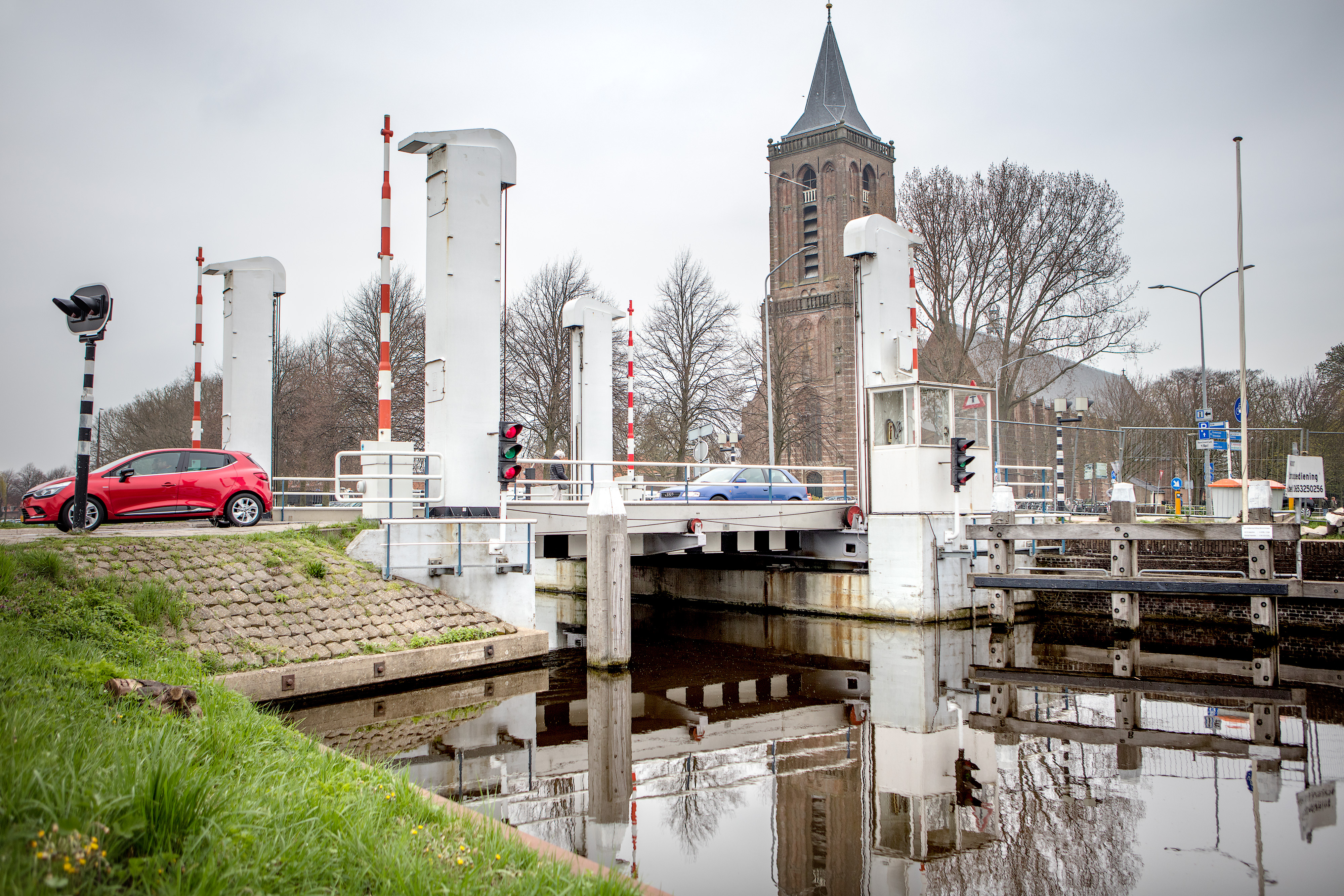 De Hefbrug Monnickendam (Bernhardbrug) met de Grote Kerk op de achtergrond en een rode auto die over de brug rijdt