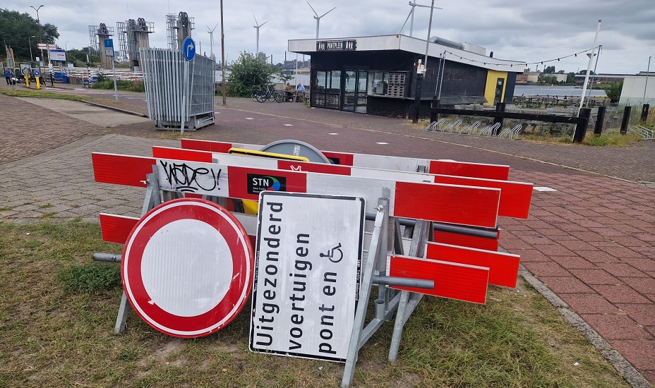 Stapel hekken voor wegafsluitingen in een berm.