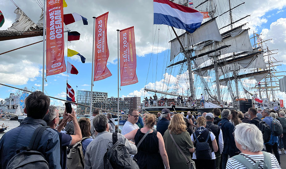 Mensen wachten op de kade om een tallship te bezoeken