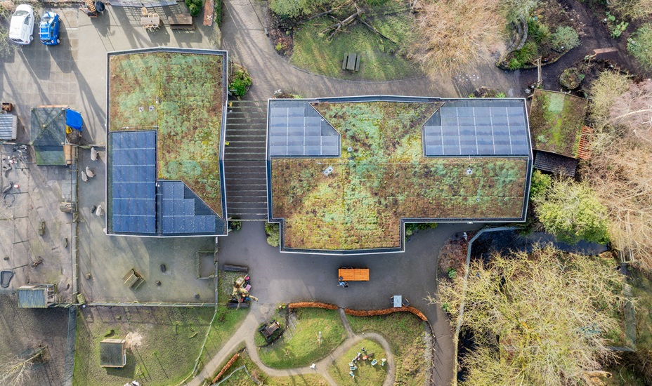 Dronefoto van Hertenkamp Enkhuizen, waarbij de zonnepanelen op het dak goed zien zijn.