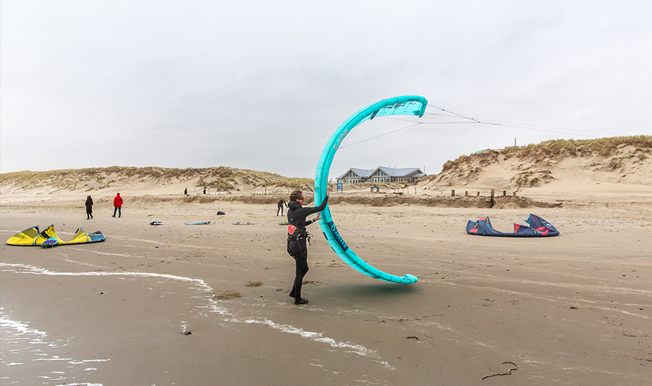 Kitesurfer met vlieger op het strand