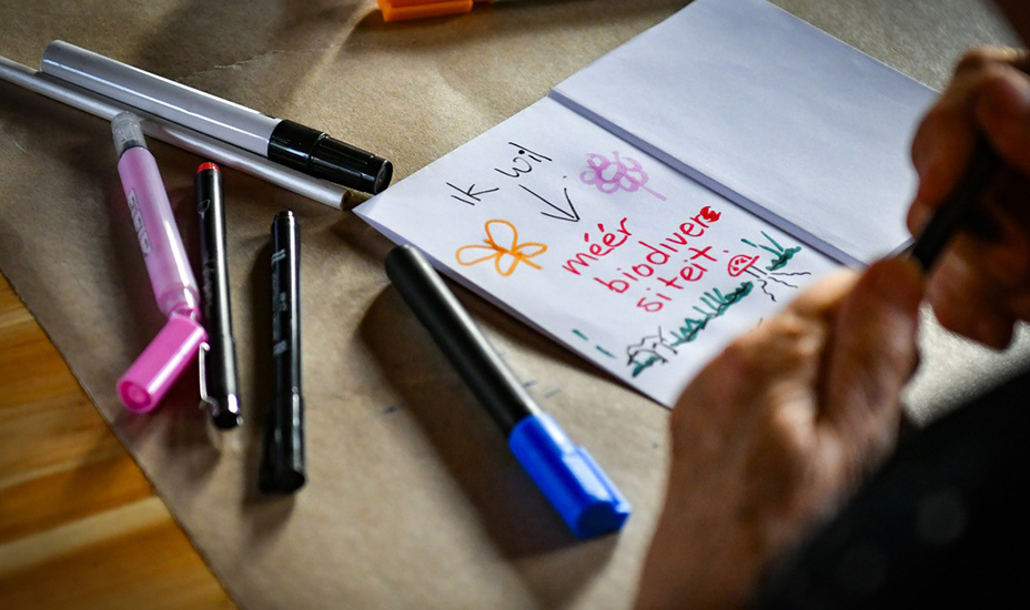 Ingezoomd op briefje met tekst 'ik wil méér biodiversiteit'