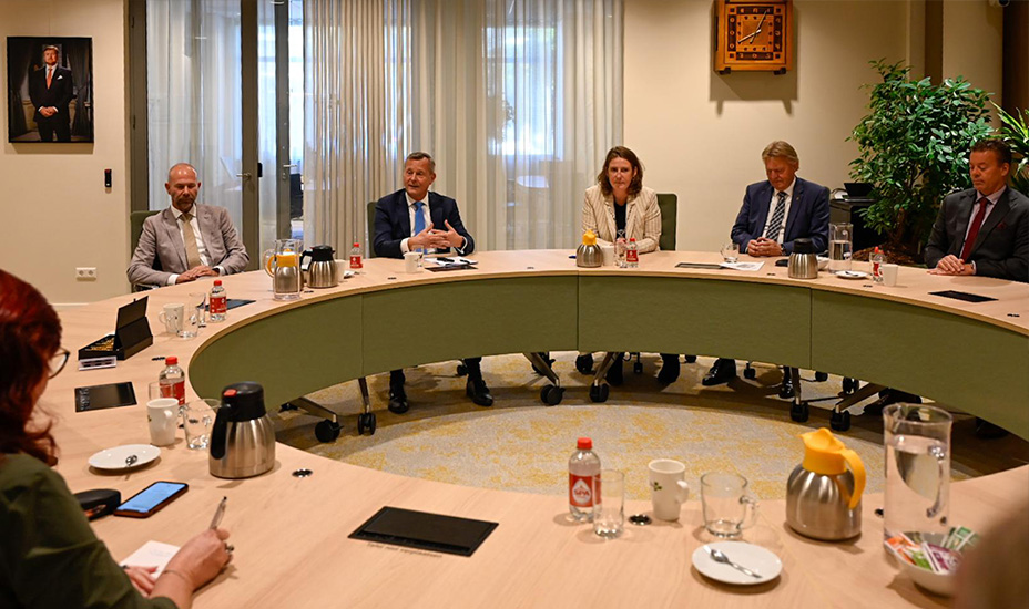 Commissaris aan tafel met college van burgemeester en wethouders aan ronde tafel