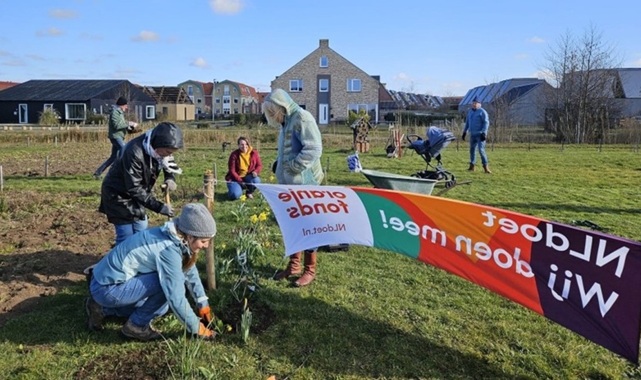Vrijwilligers van Buurtskap de Tuunen aan het werk in een weiland.