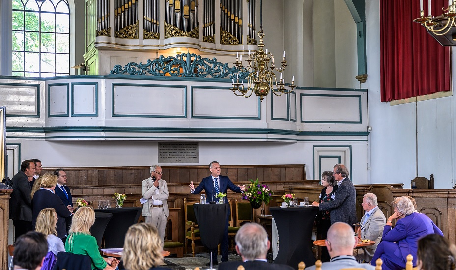 Arthur van Dijk in de kerk in gesprek met college en inwoners.