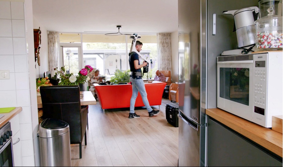 Man loopt met rugzak en LiDAR-camera door een woning.