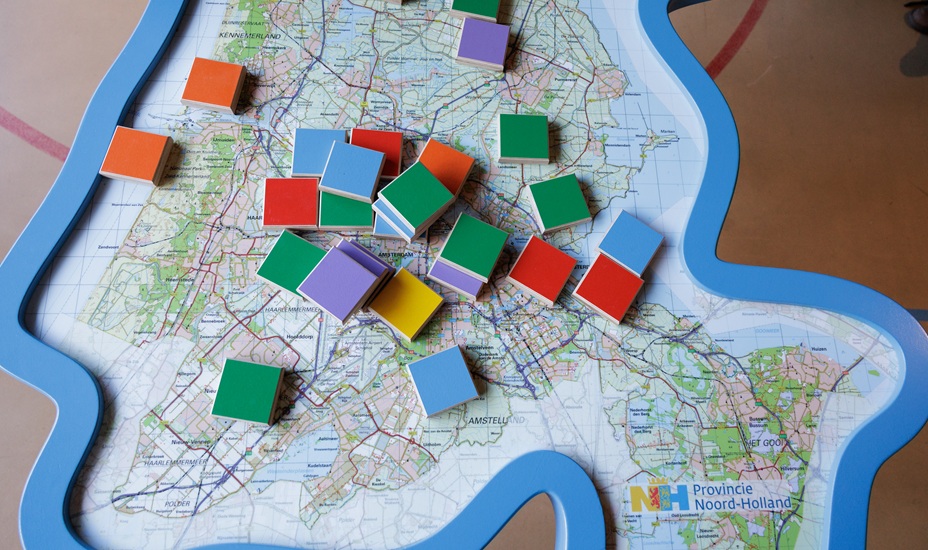 Tafel met kaart van de provincie Noord-Holland, met daarop gekleurde blokken.