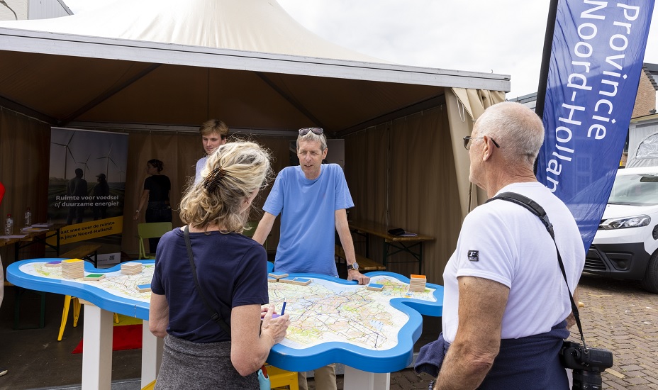 Medewerker van de provincie in gesprek met 2 bezoekers van PreSail. 