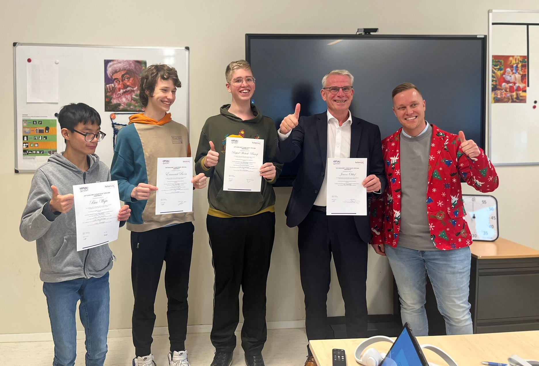 Jeroen Olthof toont met leerlingen van Heliomare hun diploma's.