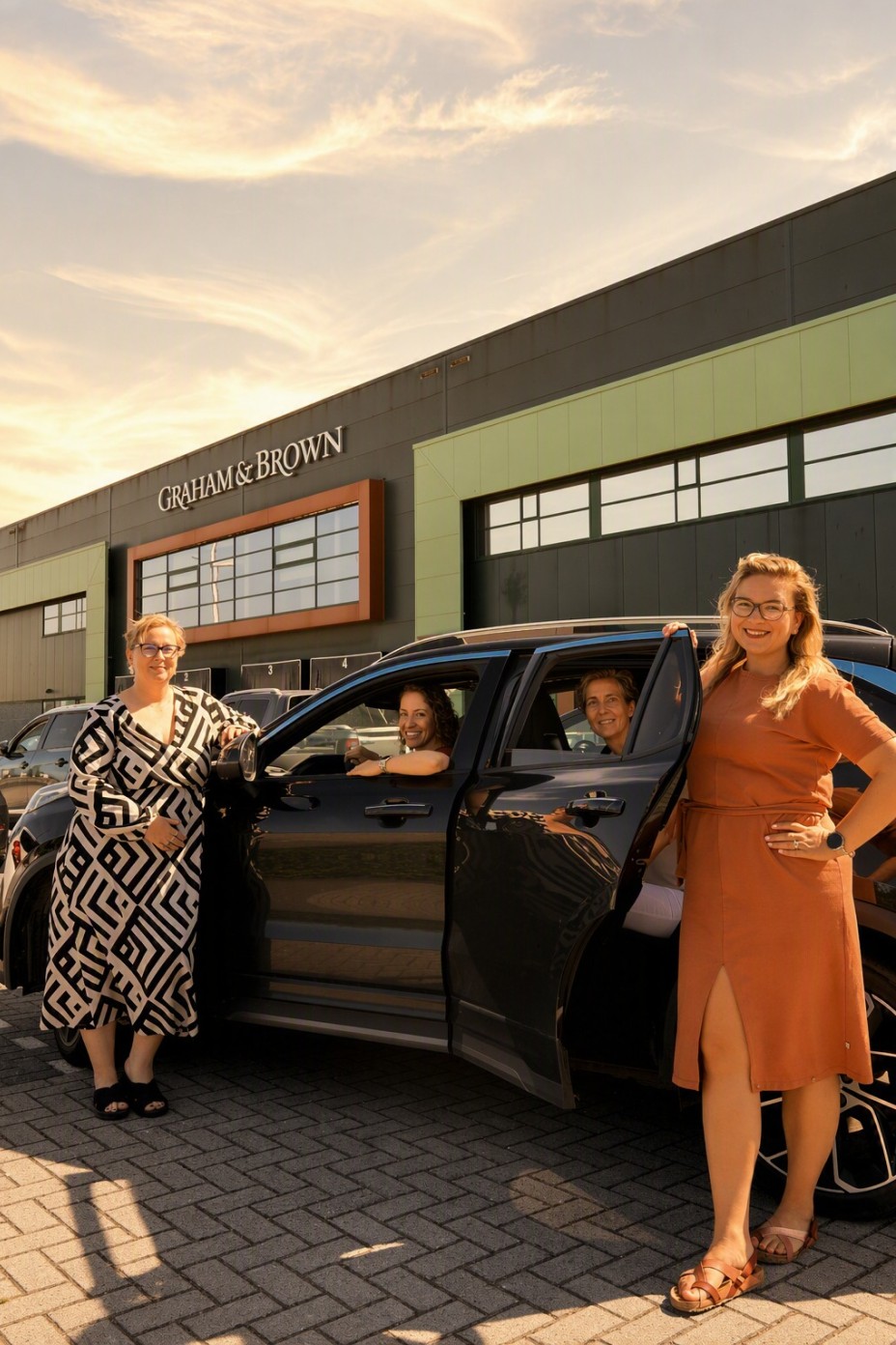 Groepsfoto van Reina, Danielle, Linda, en Joyce bij hun gedeelde auto.