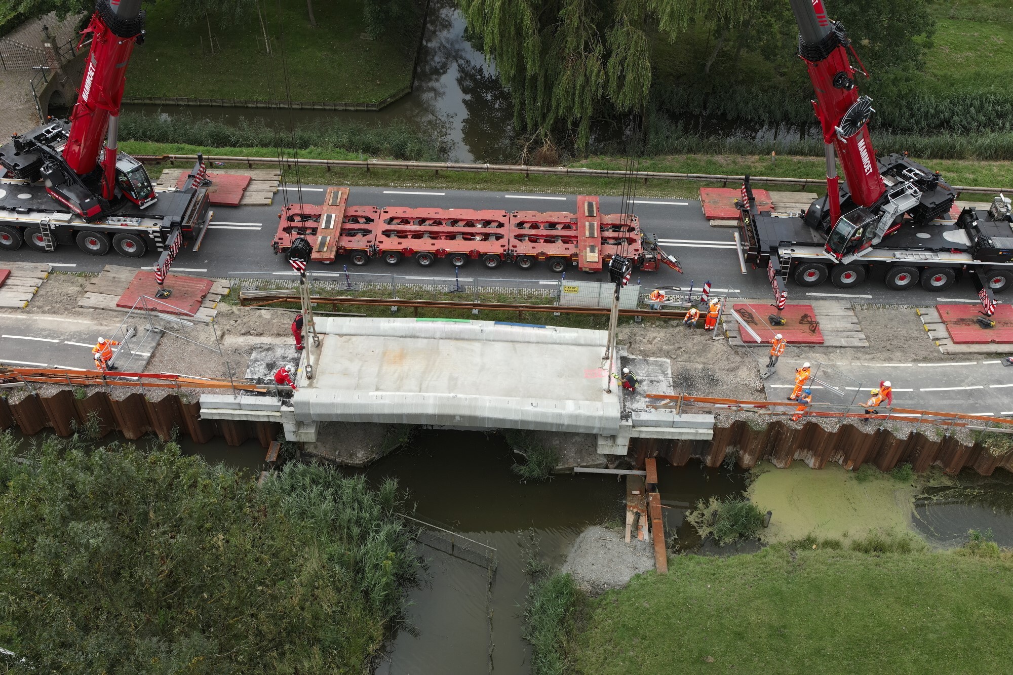 Een 3D-betongeprinte fietsbrug wordt op de definitieve plek langs de Schermerhornerweg (N243) geplaatst. Foto gemaakt op 5 augustus 2023